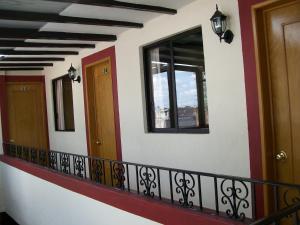 a balcony with two doors and a window at Hotel el Carmen in Morelia
