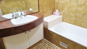 un bagno con due lavandini e uno specchio di Sandbar 302 - linen not included a Forster