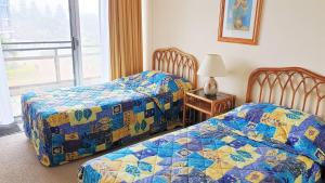 una camera da letto con due letti e un tavolo con una lampada di Sandbar 302 - linen not included a Forster Altre 5 foto