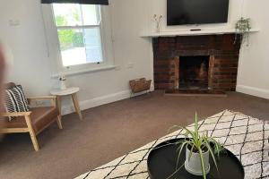 a living room with a fireplace with a tv on top at Hazeldene - The Best Location In Town! in Myrtleford