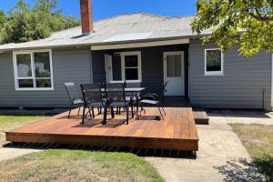 a deck with chairs and a table in front of a house at Hazeldene - The Best Location In Town! in Myrtleford
