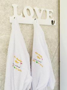 two white towels hanging on a wall with the word pray at Casa Boutique Hotel in Salento