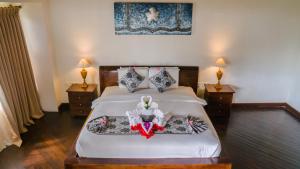 a bedroom with a bed with two night stands and two lamps at Royal Regantris Villa Karang in Gili Air