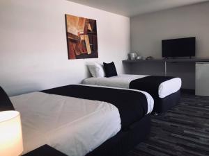 a hotel room with two beds and a flat screen tv at Guiding Star Motel & Hotel in Brooklyn