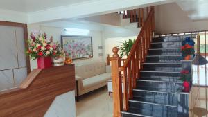 Una escalera en una sala de estar con flores. en Khách sạn Phương Nam, en Pa Hiem (1)