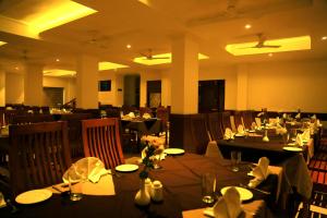 een eetkamer met tafels en stoelen in een restaurant bij Hotel Victoria International in Kattappana