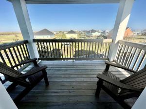 two benches sitting on a porch looking out at the ocean at #Latitude Adjustment Home in Bolivar Peninsula