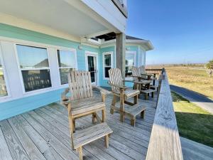 a porch with chairs and a table on a house at #Latitude Adjustment Home in Bolivar Peninsula