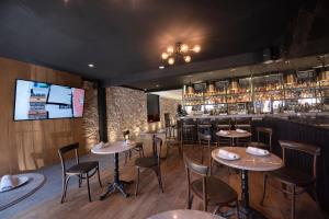 a restaurant with tables and chairs and a bar at Hotel Madi in San Miguel de Allende