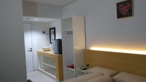 um quarto com uma cama e uma casa de banho com um espelho. em Grand Sentraland Karawang by Gkit Room em Jaken 1