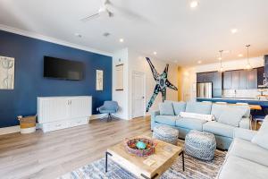 sala de estar con paredes azules y sofá azul en West Side Cottage #O, en Gulf Shores