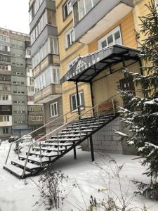 ノヴォクズネツクにあるAurooms Kontinent Hotelの雪の建物前階段