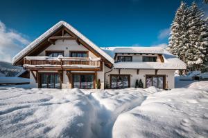 a house covered in snow with a pile of snow at Apartmány Bílá 188 in Bílá
