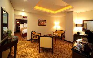 Habitación de hotel con cama y sala de estar. en Holiday Inn Olaya, an IHG Hotel en Riad
