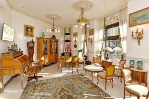 a living room with a grand piano and chairs at Royal Hotel in Varna City