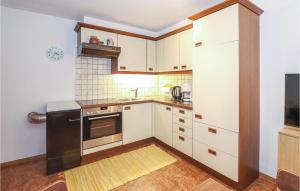 una cucina con mobili bianchi e un frigorifero nero di Ferienwohnung In Ruhiger Lage a Blons
