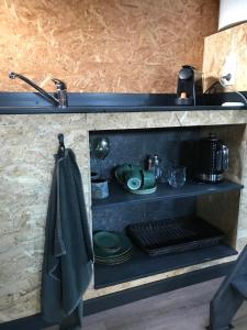 a kitchen with a stove and a towel on a shelf at De Tuinschuur in Empe