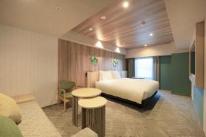 a hotel room with a bed and two tables at Richmond Hotel Morioka Ekimae in Morioka