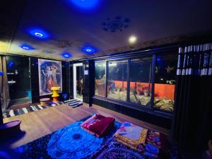 a living room with a large aquarium in the background at Bhoora House in Jaipur