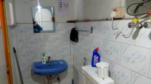a bathroom with a blue sink and a toilet at Darjeeling Home in Darjeeling