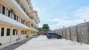 ein Auto, das auf einem Parkplatz neben Gebäuden parkt in der Unterkunft RedDoorz Plus near Talisay Town Center in Talisay