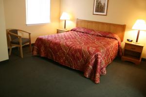 um quarto de hotel com uma cama e uma cadeira em Affordable Suites Wilson em Wilson