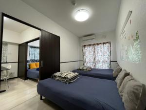 a bedroom with two beds and a window at EX Itoman Apartment 301 in Itoman