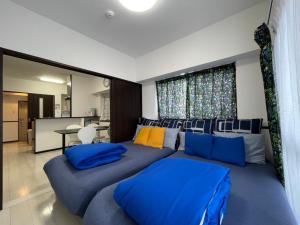 una sala de estar con almohadas azules en un sofá en EX Itoman Apartment 301, en Itoman