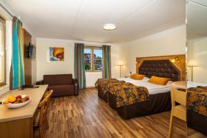 una camera d'albergo con letto, divano e tavolo di Hotel Vallonia a Vaasa