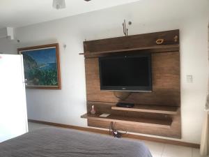 a bedroom with a flat screen tv on a wall at Flat em Resort incrivel a 10 min da Esplanada, STF e PGR in Brasília