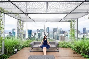 a woman sitting on a bench on top of a building at Ceylonz Suites by EdenZpace in Kuala Lumpur