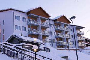 a building with snow in front of it at Ukkohalla Chalets in Hyrynsalmi