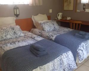 a room with two beds with towels on them at Lutea Guest House in Mokopane