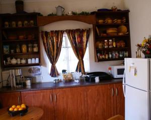 a kitchen with a white refrigerator and a window at Lutea Guest House in Mokopane