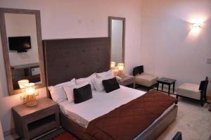 a bedroom with a large bed with a large mirror at Solo Victoria Hotel in New Delhi