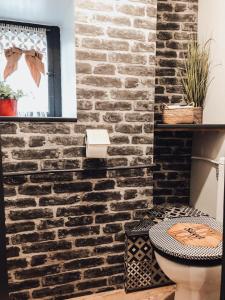 a bathroom with a brick wall and a toilet at Les gites de Marie in Boulogne-sur-Mer +32 photos