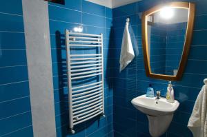 a blue bathroom with a sink and a mirror at Cabana Valea Bradului in Nucşoara +12 photos