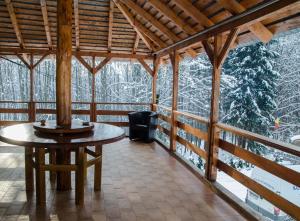 a room with a table and a chair in a cabin at Cabana Valea Bradului in Nucşoara