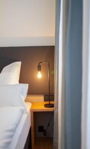 a bedroom with a bed and a lamp on a table at Le Baldinger Boutique Hotel in Bamberg