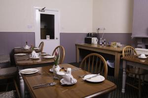 a dining room with wooden tables and chairs at Fourways Guest House in Thirsk