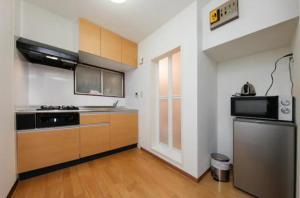 a kitchen with a stove and a refrigerator at Ikebukuro Apartment in Tokyo