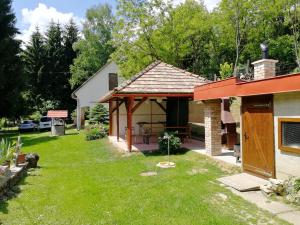 un patio trasero de una casa con patio en Római Fürdő Apartmanház, en Bakonynána