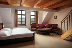1 dormitorio con cama, sofá y ventanas en Hotel Javor en Adršpach