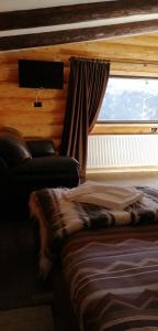 un dormitorio con una cama y una ventana en Cabanele silvania 1, en Statjunea Borsa
