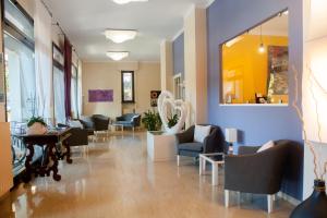 a waiting room with chairs and tables and a mirror at Residence La Palma in Marina dʼAndora