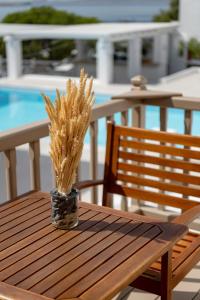 a wooden table with a vase with grass on it at Lithos by Spyros & Flora in Agios Ioannis Mykonos