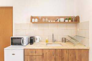 a kitchen with a sink and a microwave at Port City Haifa in Haifa