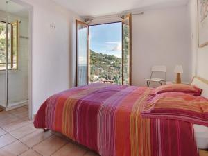 um quarto com uma cama e uma grande janela em The frogs' house - Yoga Retreat em Saint-Jeannet