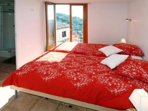 uma cama vermelha num quarto com uma janela em The FrogS' House - Yoga Retreat em Saint-Jeannet