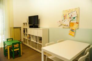 a classroom with a table and a tv on a wall at Residence La Palma in Marina di Andora